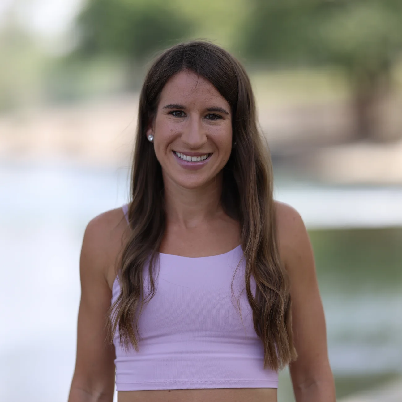 Coach Lindsey Quebedeaux smiling by the water.